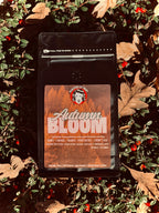 Coffee package labeled 'Autumn Bloom' on a leafy background