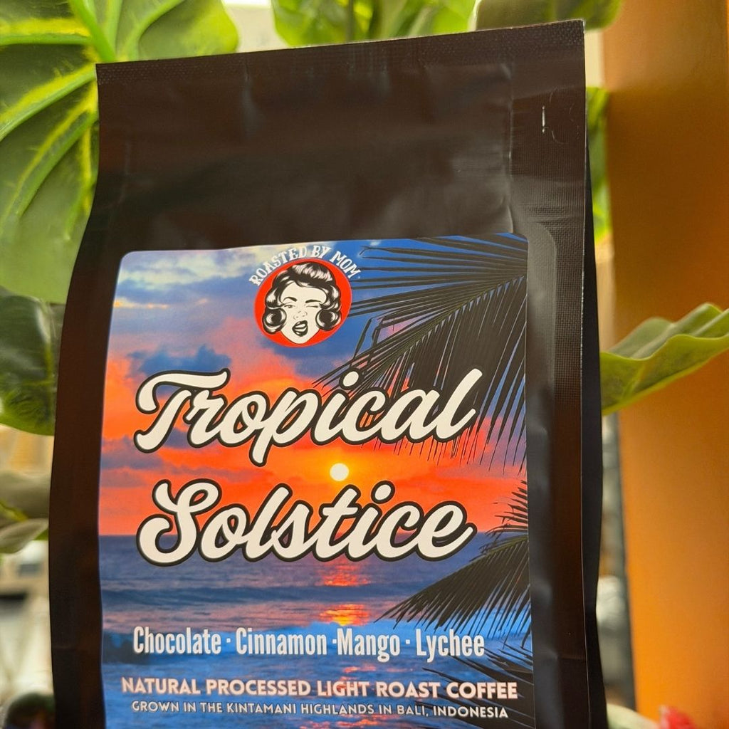 Coffee bag labeled 'Tropical Solstice' with a scenic design on a plant background