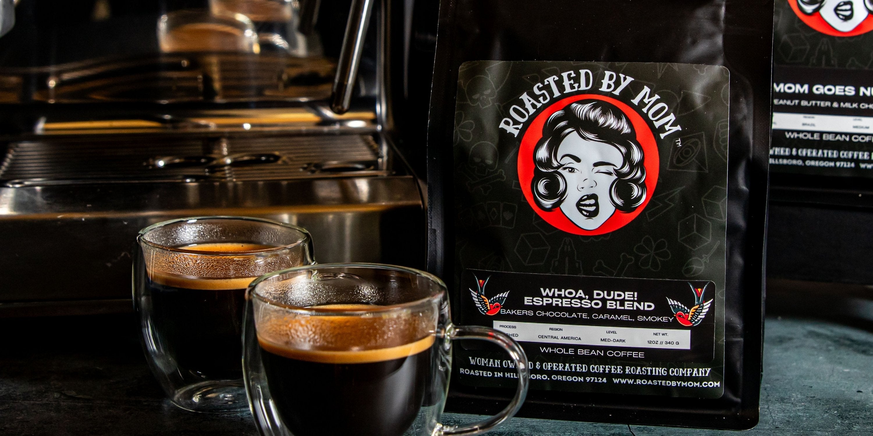 Coffee bag labeled 'Roasted by Mom' with two cups of coffee in front