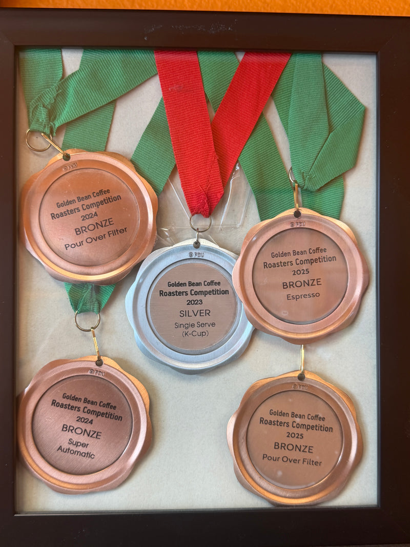 Set of four medals with ribbons in a display case